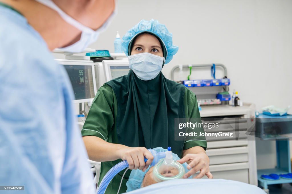 Anestesista usando ventilador na paciente sênior