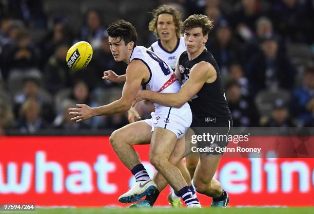 Andrew Brayshaw of the Dockers handballs whilst being tackled by Paddy Dow of the Blues during the round 13 AFL match between the Carlton Blues and...