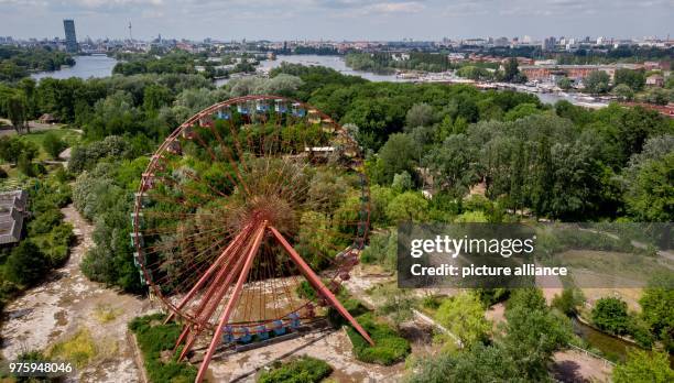 Dpatop - 25 May 2018, Germany, Berlin: A ferris wheel standing in the former GDR amusement 'Spreepark' looms over the Plaenterwald area. The...