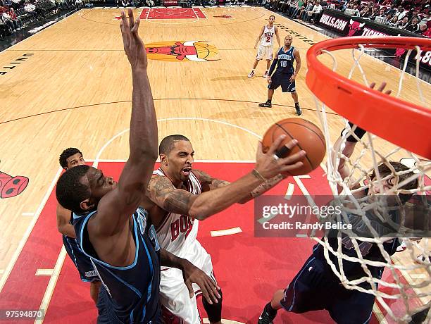 Acie Law of the Chicago Bulls jumps toward the basket past Paul Millsap of the Utah Jazz during the NBA game on March 09, 2010 at the United Center...