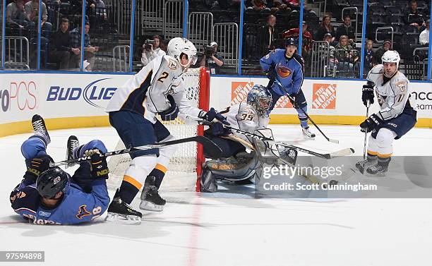 Dan Ellis of the Nashville Predators makes a save against Niclas Bergfors of the Atlanta Thrashers at Philips Arena on March 9, 2010 in Atlanta,...