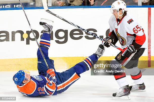 Robert Nilsson of the Edmonton Oilers is upended by Erik Karlsson of the Ottawa Senators at Rexall Place on March 9, 2010 in Edmonton, Alberta,...