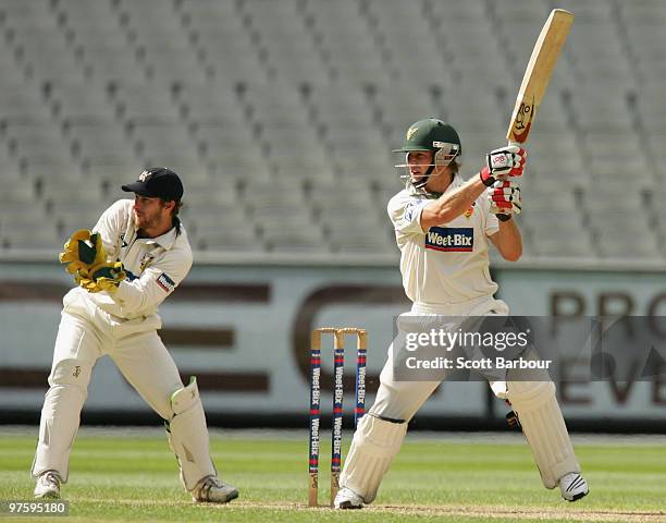 Tim Paine of the Tigers plays a cut shot as Bushrangers wicketkeeper Matthew Wade watches during day one of the Sheffield Shield match between the...