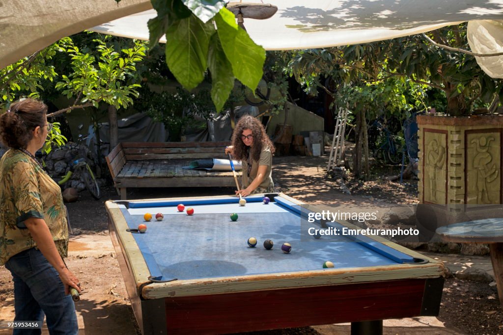 Playing billiard at an old pool table in a camp.