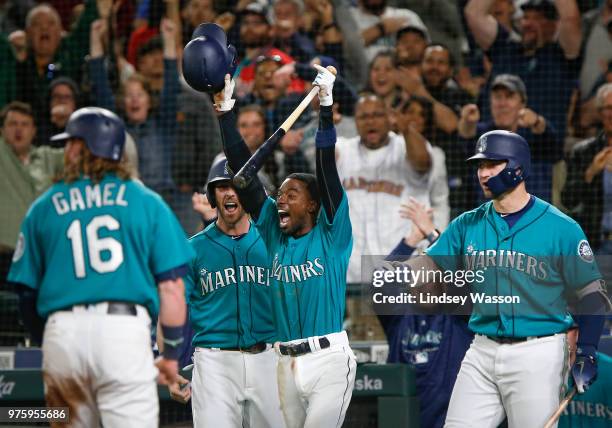 Dee Gordon of the Seattle Mariners, center throws his hands up as Ben Gamel is called safe at home and gives the Mariners the lead over the Boston...