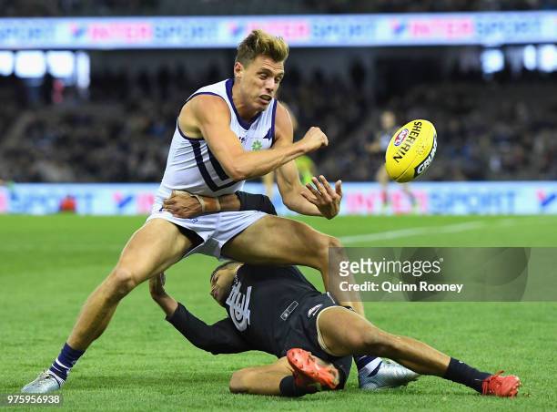 Tom Sheridan of the Dockers handballs whilst being tackled by Sam Petrevski-Seton of the Blues during the round 13 AFL match between the Carlton...
