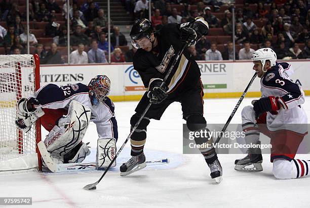 Goaltender Mathieu Garon of the Columbus Blue Jackets defends his net as Bobby Ryan of the Anaheim Ducks makes a backhand pass between his legs into...