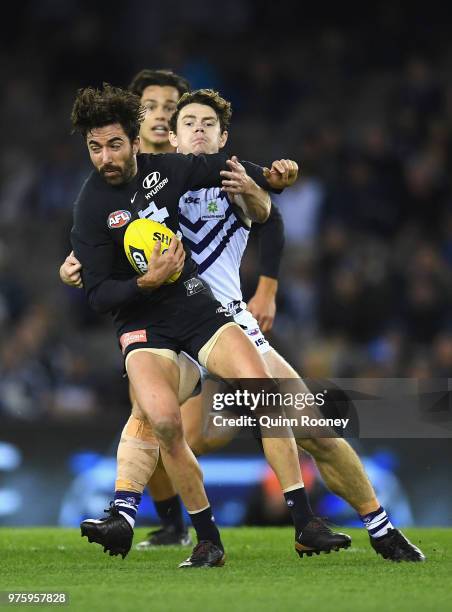 Kade Simpson of the Blues is tackled by Lachie Neale of the Dockers during the round 13 AFL match between the Carlton Blues and the Fremantle Dockers...