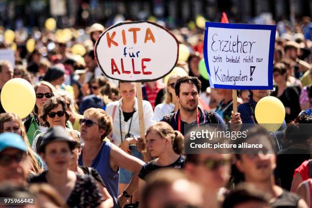 May 2018, Germany, Berlin: Parents and educators carrying a 'Kita fuer alle' sign demand more daycare places to be available for their children and...