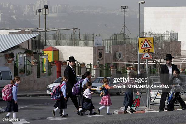 Israeli school girls and boys cross a street in Ramat Shlomo, a Jewish settlement in the mainly Arab eastern sector of Jerusalem, on March 10, 2010....