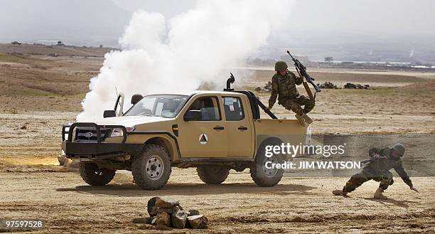 Afghan troops react in a simulated Improvised Explosive Device scenario during a demonstration for visiting Defense Minister Abdul Rahim Wardak and...