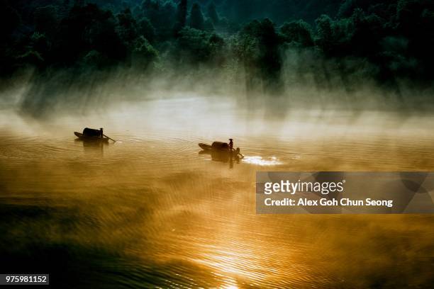 two boats swimming through morning mist on dongjiang lake, chenzhou, hunan province, china - hunan province stock-fotos und bilder