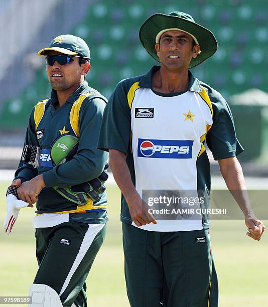 In this picture taken on February 28 Pakistan�s cricket captain Younus Khan arrives with teammate Kamran Akmal for a training session at The Gaddafi...