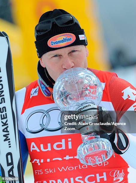 Didier Cuche of Switzerland takes the globe for the overall World Cup Downhill during the Audi FIS Alpine Ski World Cup Men's Downhill on March 10,...