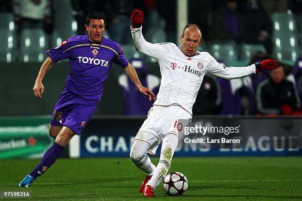 Mario Bolatti of Florence challenges Arjen Robben of Muenchen during the UEFA Champions League round of sixteen, second leg match between AFC...