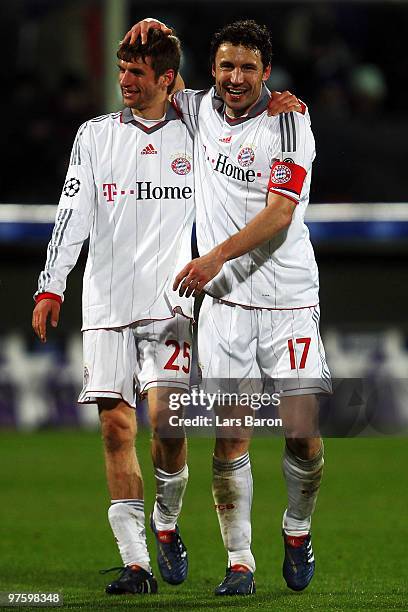 Thomas Mueller of Muenchen celebrates with team mate Mark van Bommel after the UEFA Champions League round of sixteen, second leg match between AFC...