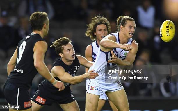 Nat Fyfe of the Dockers handballs whilst being tackled by Paddy Dow of the Blues during the round 13 AFL match between the Carlton Blues and the...