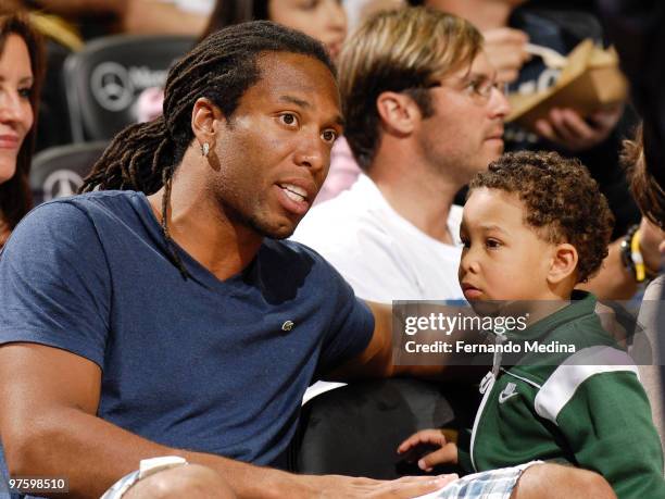 Larry Fitzgerald of the Phoenix Cardinals and his son Devin sit courtside during the game between the Los Angeles Clippers and the Orlando Magic on...