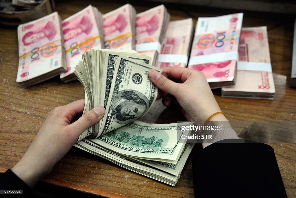 A Chinese bank worker counts a stack of