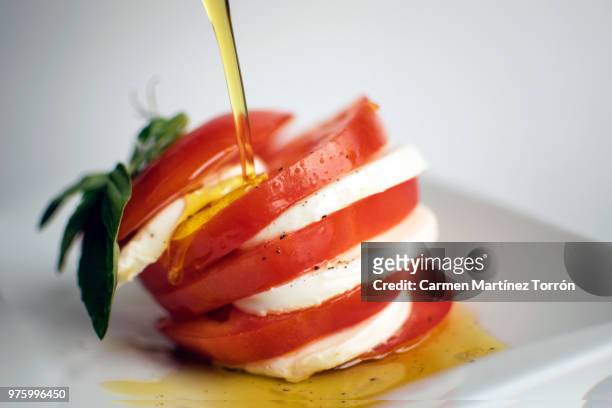 oil on caprese salad with pepper. - caprese imagens e fotografias de stock