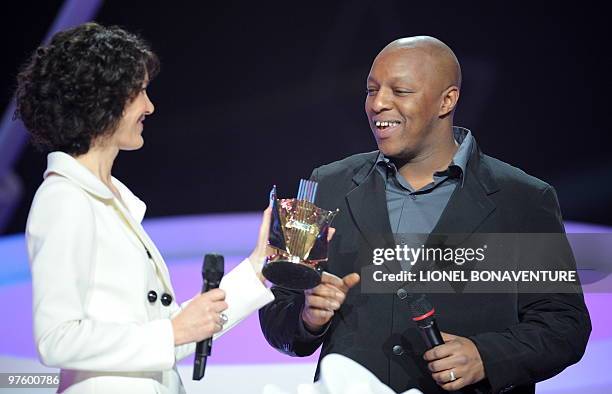 French rap singer Oxmo Puccino receives the award for best urban music album of the year for "L'Arme de paix" from TV host Caroline Tresca during the...