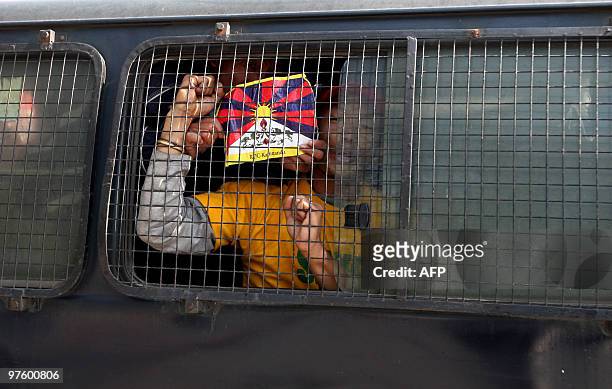 Tibetan activist shouts slogans from the back of a police vehicle following their arrest by Nepalese riot police in front of the consular section of...