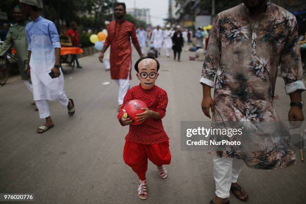 Dhaka, Bangladesh. A Bangladeshi girl wears mask as she celebrates Eid-ul-Fitr festival in Dhaka, Bangladesh on June 16, 2018. Muslims around the...