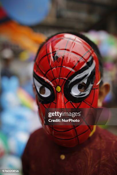 Dhaka, Bangladesh. A Bangladeshi boy wears mask as he celebrates Eid-ul-Fitr festival in Dhaka, Bangladesh on June 16, 2018. Muslims around the world...