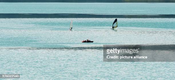 May 2018, Germany, Walchensee: Two surfers and a pedalo on Walchensee . Photo: Peter Kneffel/dpa