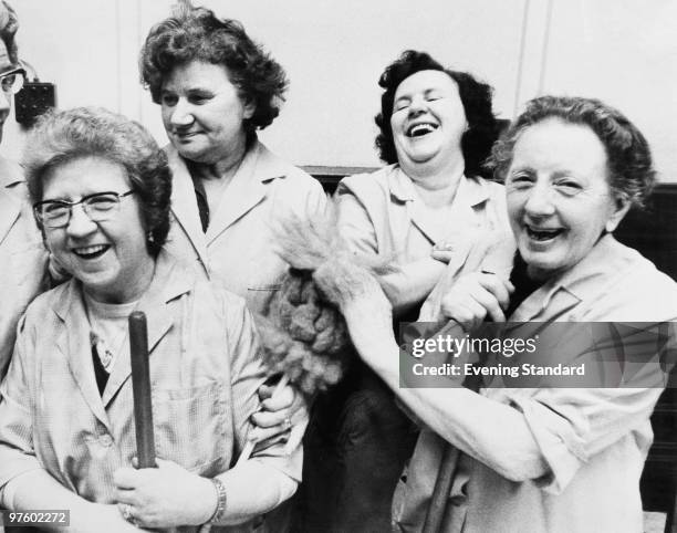 Cleaning women celebrate equal pay day at Kensington Town Hall in London, January 1975. From left to right, Mrs Florrie Cole, Mrs Lily Davis, Mrs Ann...