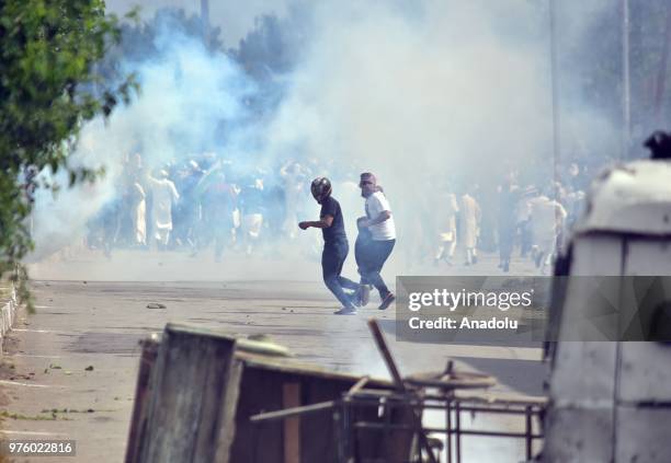 Protesters run after Indian paramilitary soldiers fire tear gas canisters during an anti-India protest after Eid al-Fitr prayer on the Eid al-Fitr...