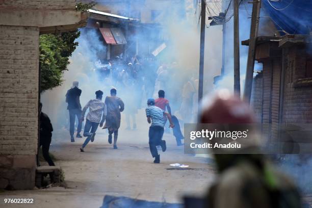 Protesters run after Indian paramilitary soldiers fire tear gas canisters during an anti-India protest after Eid al-Fitr prayer on the Eid al-Fitr...