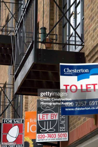 Estate agent letting and selling boards mounted on the exterior of refurbished apartments.