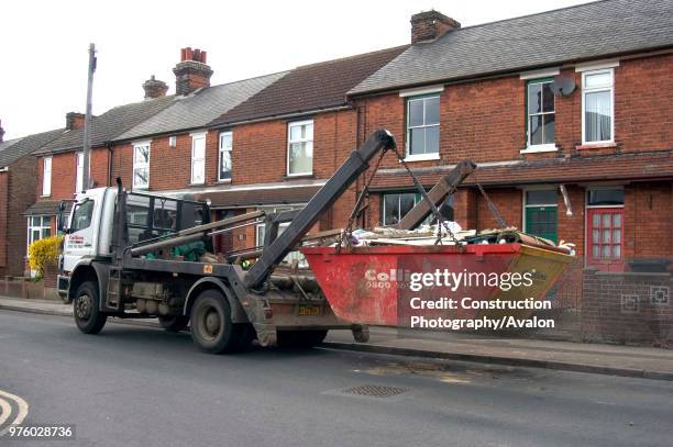 Skip loader collecting a skip.