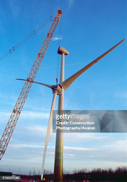 The hub and blades of a large Enercon wind turbine are winched into position at dawn Worksop United Kingdom 2008.