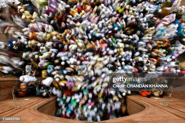 Indian Muslims leave after offering Eid al-Fitr prayers at the Jama Masjid mosque in New Delhi on June 16, 2018. - Muslims around the world...