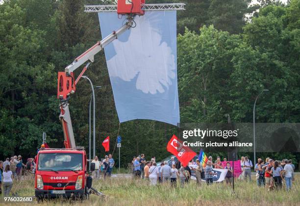 May 2018, Germany, Brueck: A flag with a dove of peace is fixed to a crane during a protest rally of the Brandenburg The Left party against a US...