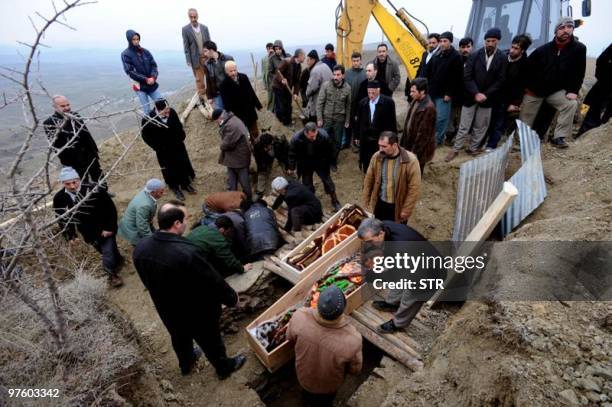 Survivors of a killer earthquake mourn relatives as they bury members of their families in the village of Yukari Demirciler, on March 9, 2010. A...