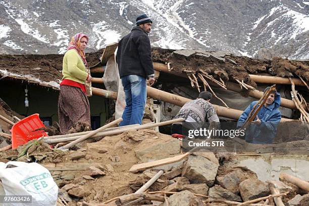 Survivors of a killer earthquake stand among debris of their houses in the village of Yukari Demirciler, on March 9, 2010. A powerful pre-dawn...