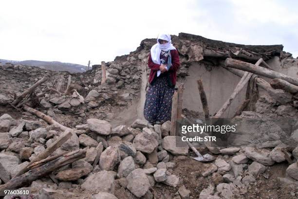Woman stands in front of her destroyed house in Karakocan, in the southeastern Elazig province, on March 8, 2010. At A powerful earthquake in eastern...