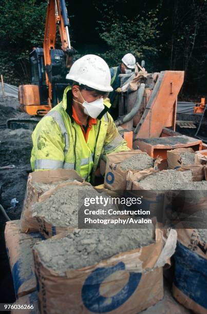 Feeding cement into the grout mixer for the injection into old mine workings Ironbrige, UK.