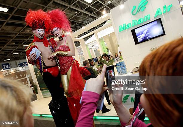 Visitors photograph a couple on stilts promoting Ibiza at the ITB Berlin travel trade show on March 10, 2010 in Berlin, Germany. The ITB, which is...