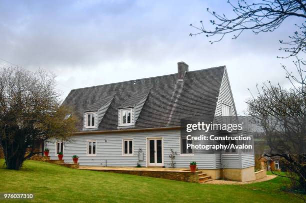 Timber clad house with a gravel drive Gloucestershire UK.