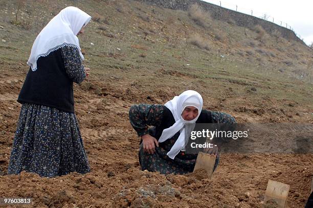 Relatives of earthquake victims mourn at the cemetery of the village of Okcular in the eastern Turkish province of Elazig on March 9 a day after an...