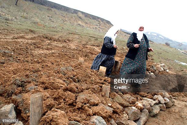 Relatives of earthquake victims walk in the cemetery of the village of Okcular in the eastern Turkish province of Elazig on March 9 a day after an...