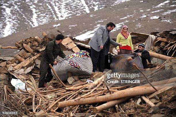 Residents of the remote eastern Turkish village of Yukari Demirciler scramble to collect any remaining valuables from the wreckage of their...