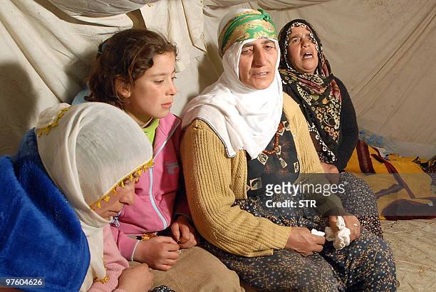 Earthquake victims mourn as they shelter in a tent in Okcular village in the eastern province of Elazig, early on March 9 hours after a strong...