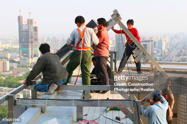 Construction workers install a neon sign at Fortune Plaza in Beijing.