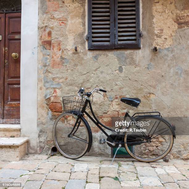 italian old-style bicycles leaning against a wall in the historic centre of ferrara - ravenna stock pictures, royalty-free photos & images