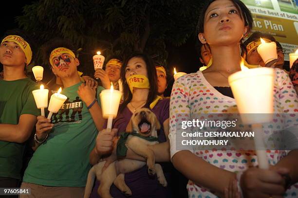 Members of 'Students for Free Tibet' gesture as they hold a candlelight demonstration in Kolkata on March 10 to mark the 51st anniversary of the...